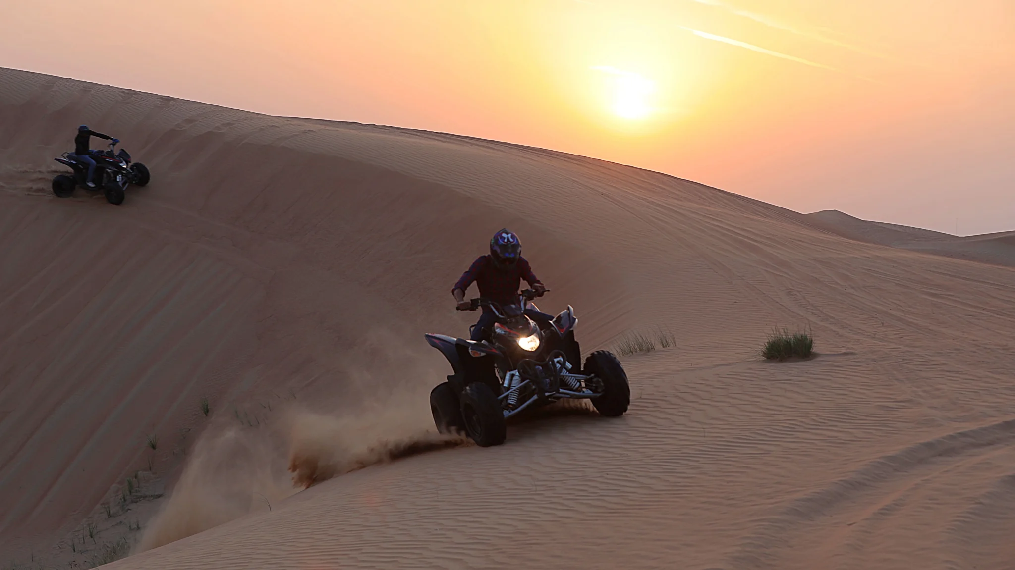 Quad bike on a red dune at sunset in Dubai